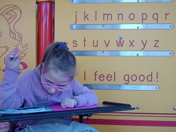 a child reading in front of the Braille wall at Fairmount park